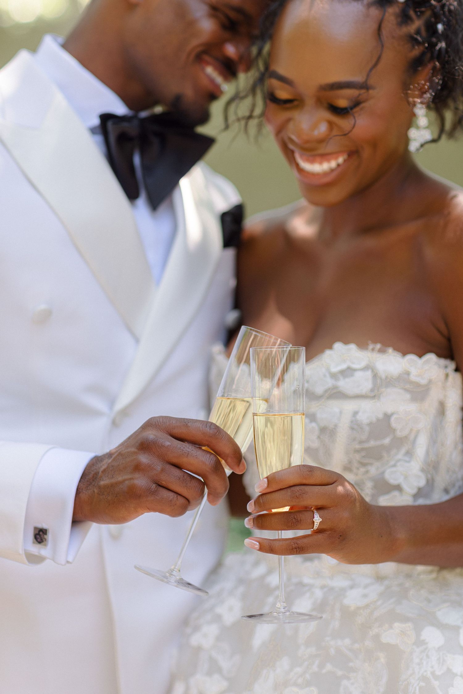 Wedding couple shares an intimate moment while toasting with champagne glasses.