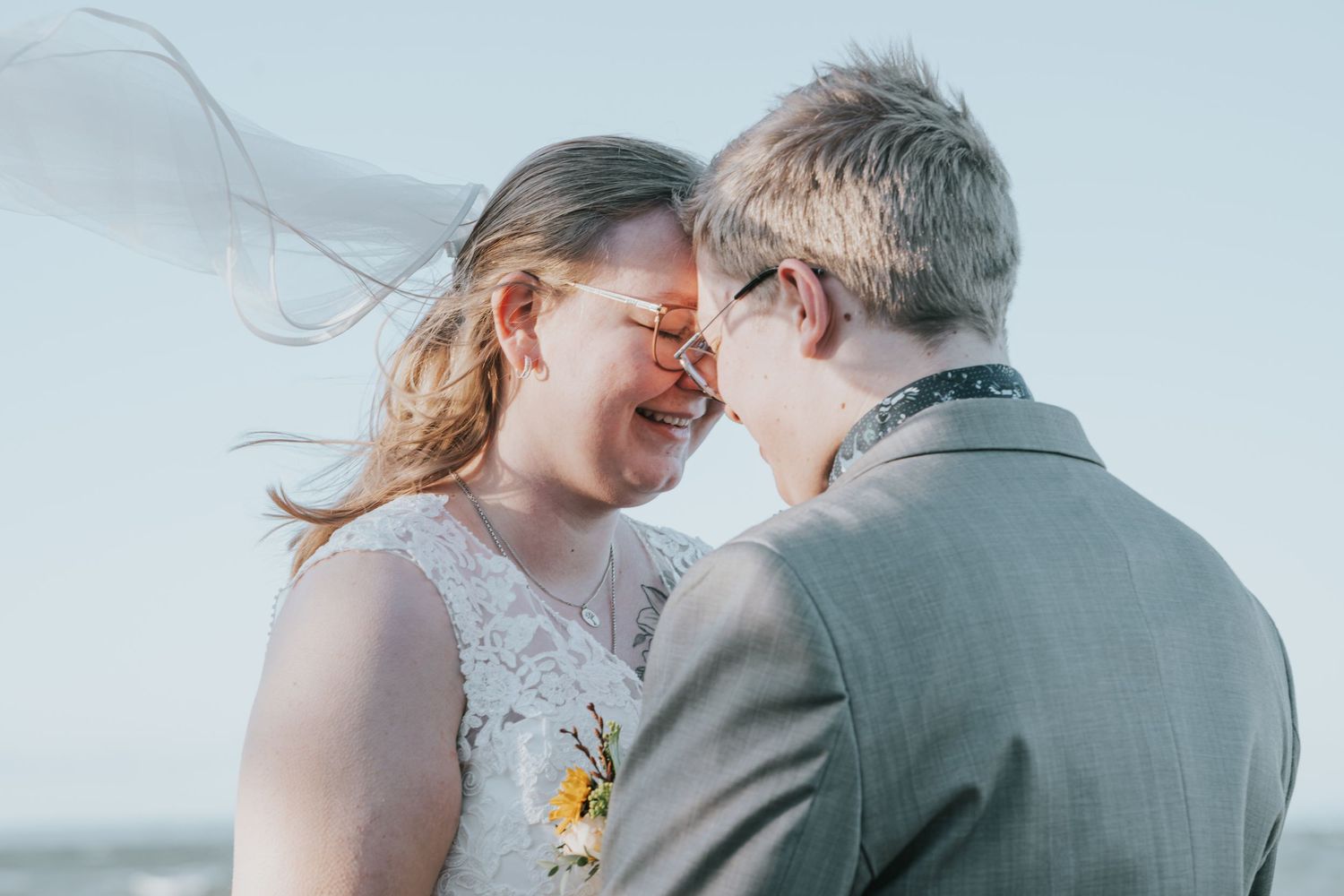 A couple in wedding attire share joyful moments together during their outdoor ceremony.