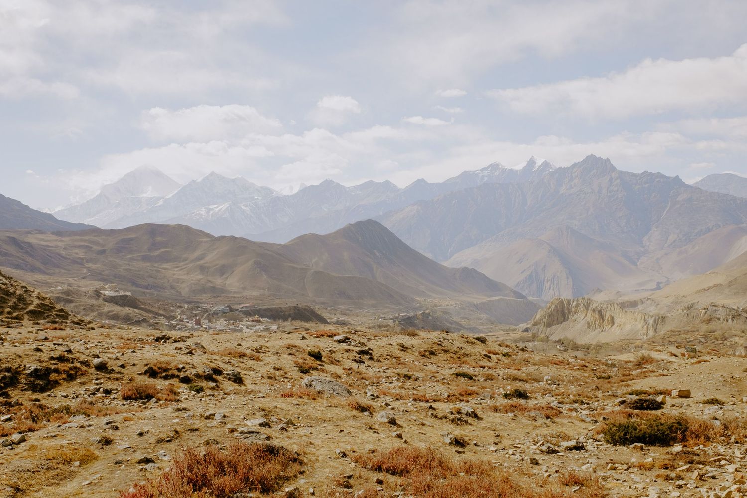 Panoramic view of rugged mountain ranges with snow-capped peaks stretching across the horizon.