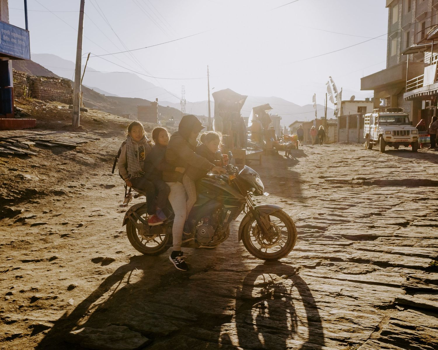 A cinematic sequence of motorcycle riders silhouetted against a golden sunset on a dusty road.