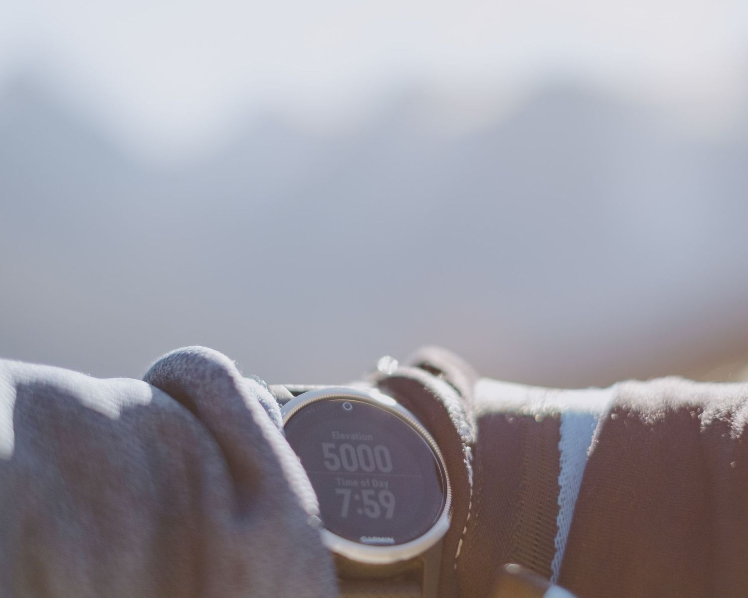 Close-up view of an altimeter or measuring device showing 5000 against a blurred mountain background.