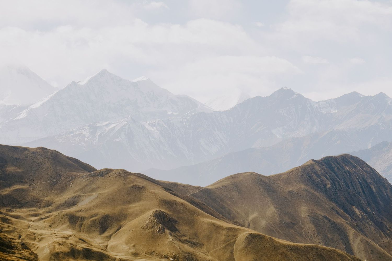 Majestic mountain range stretches across the horizon under bright blue skies.