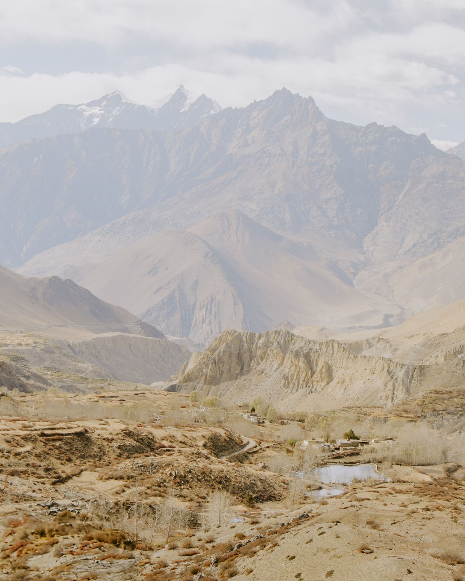 Panoramic view of snow-capped mountain peaks and valleys in a remote mountainous landscape.