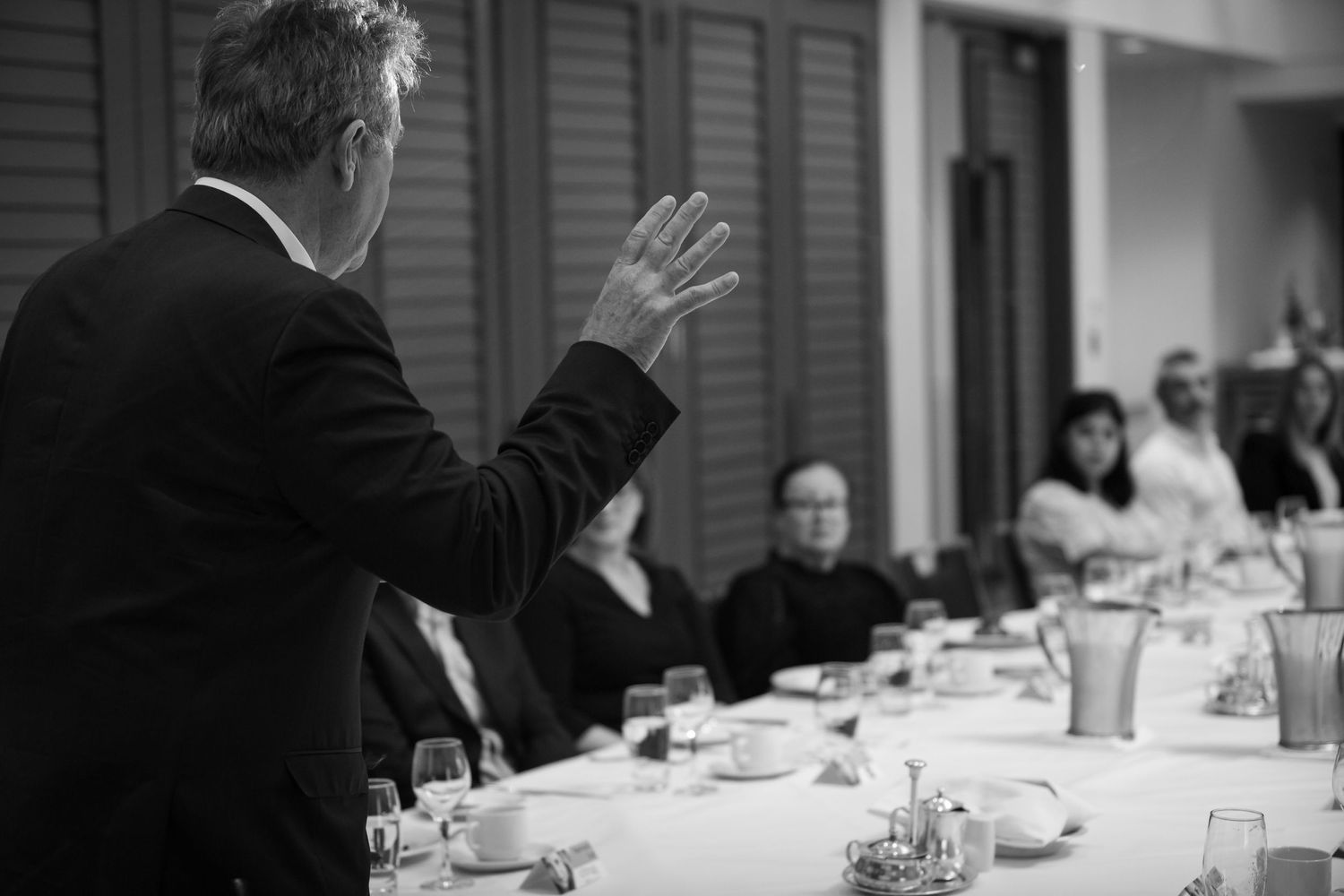 Sydney Event Photography - A speaker gestures while presenting to an audience at a business meeting.