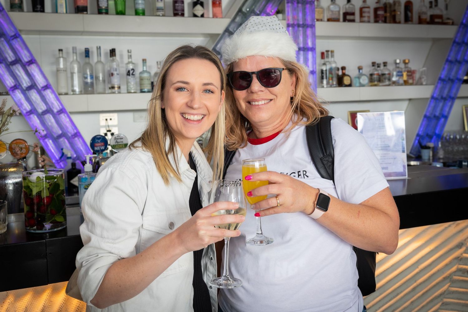 Sydney Event Photography - Friends toasting drinks at bar with purple LED lighting.