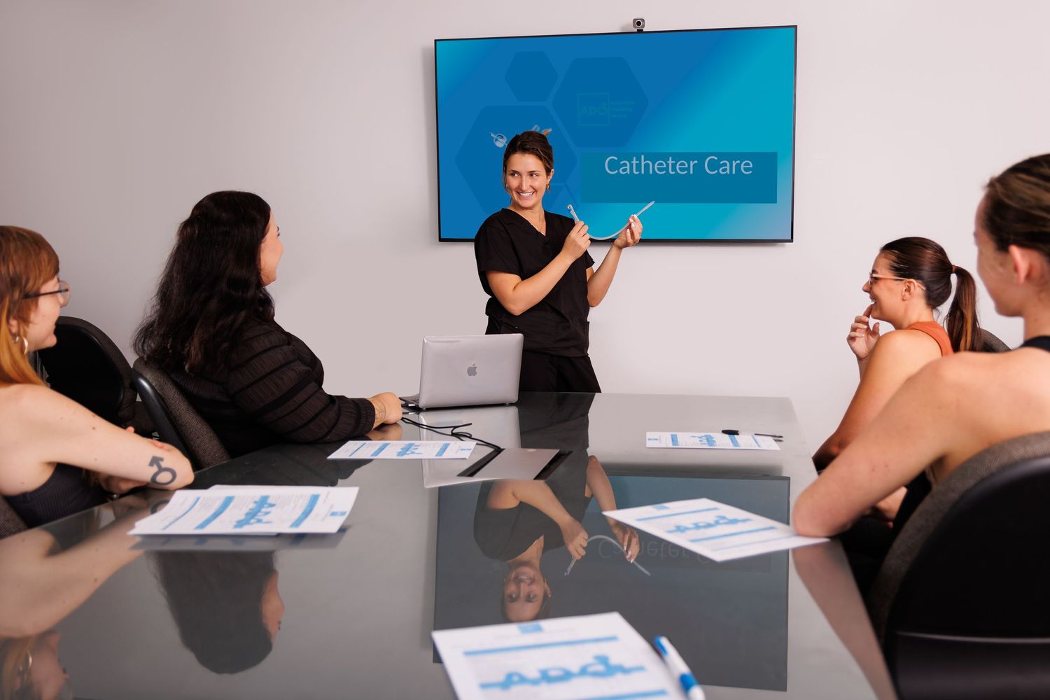 Corporate training session in modern conference room with blue presentation screen.