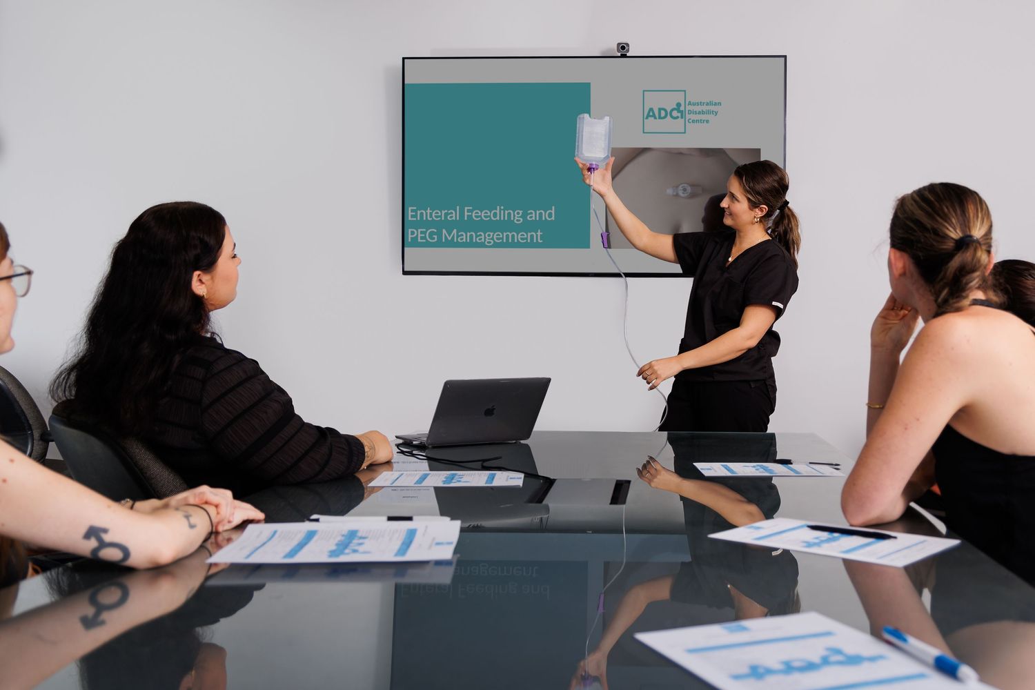 Business presentation in a modern conference room with presenter at whiteboard.