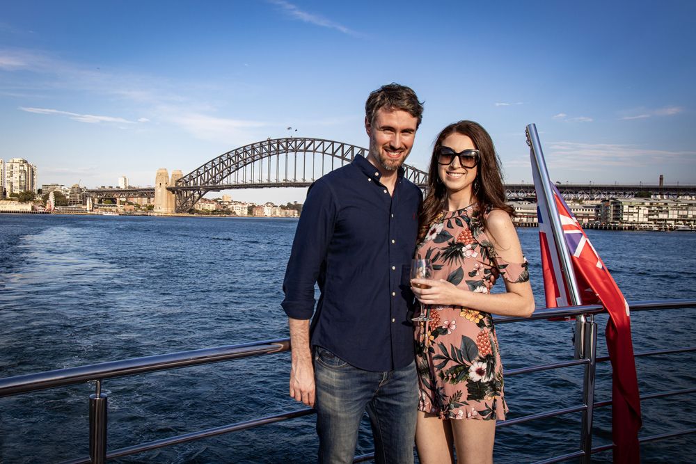 Sydney Event Photography - A couple poses on a boat with Sydney Harbour Bridge in the background.