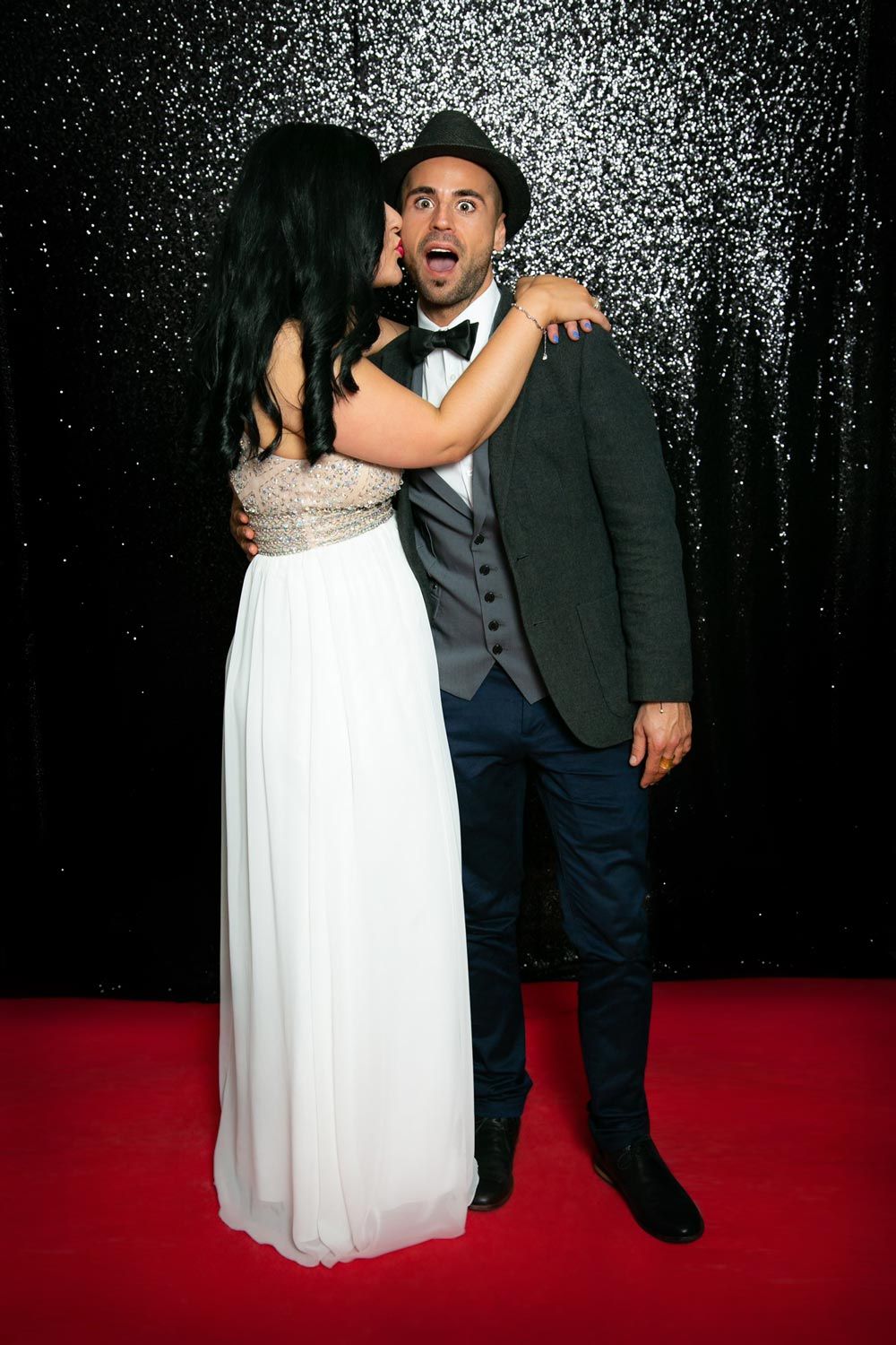 Sydney Event Photography - A couple poses dramatically against a sparkly backdrop during a formal event.