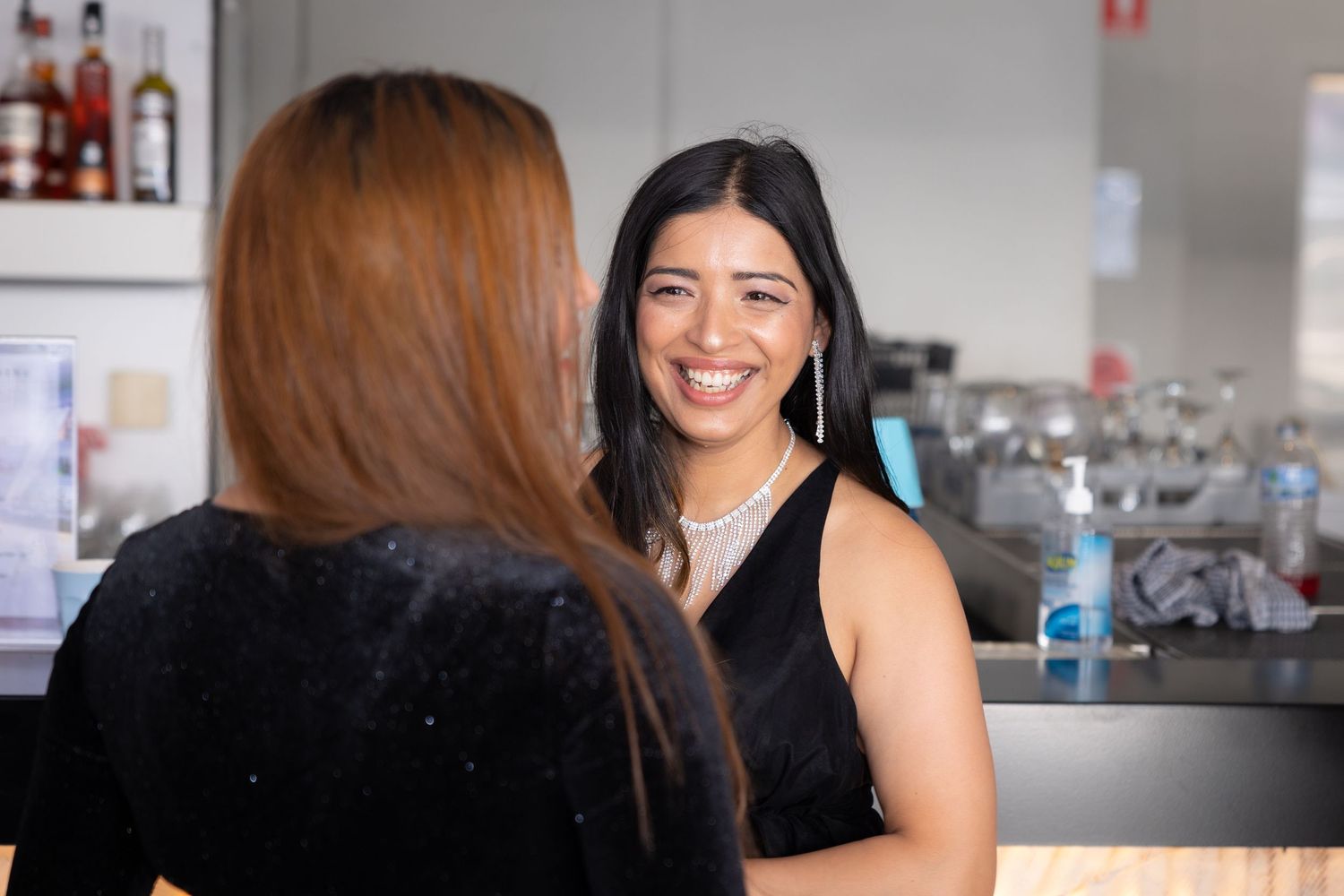 Sydney Event Photography - Two people having a friendly conversation at a bar counter.