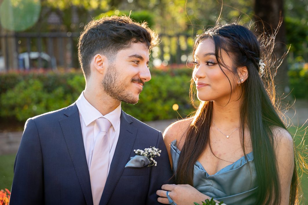 Sydney Event Photography - Couple in formal attire shares intimate moment in garden setting.