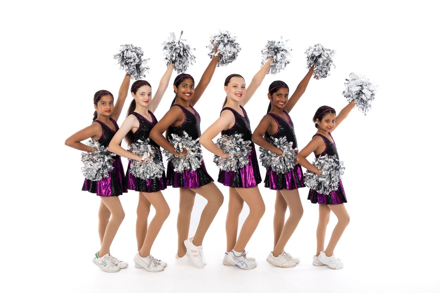 A cheerleading team in black and purple uniforms poses with silver pom-poms against a white background.