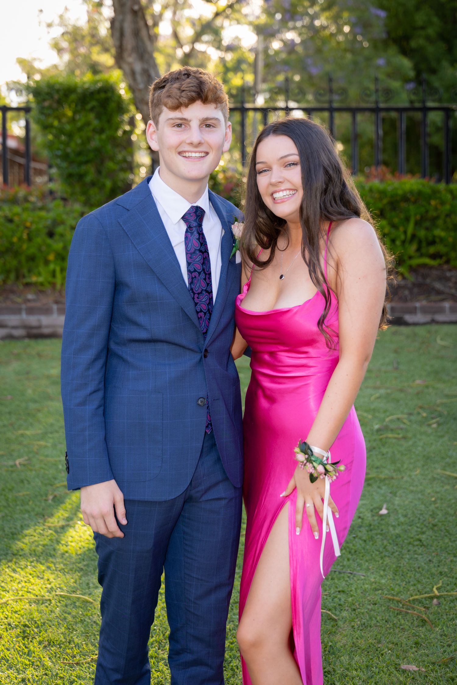 Sydney Event Photography - A couple in formal attire poses together on grass during golden hour.