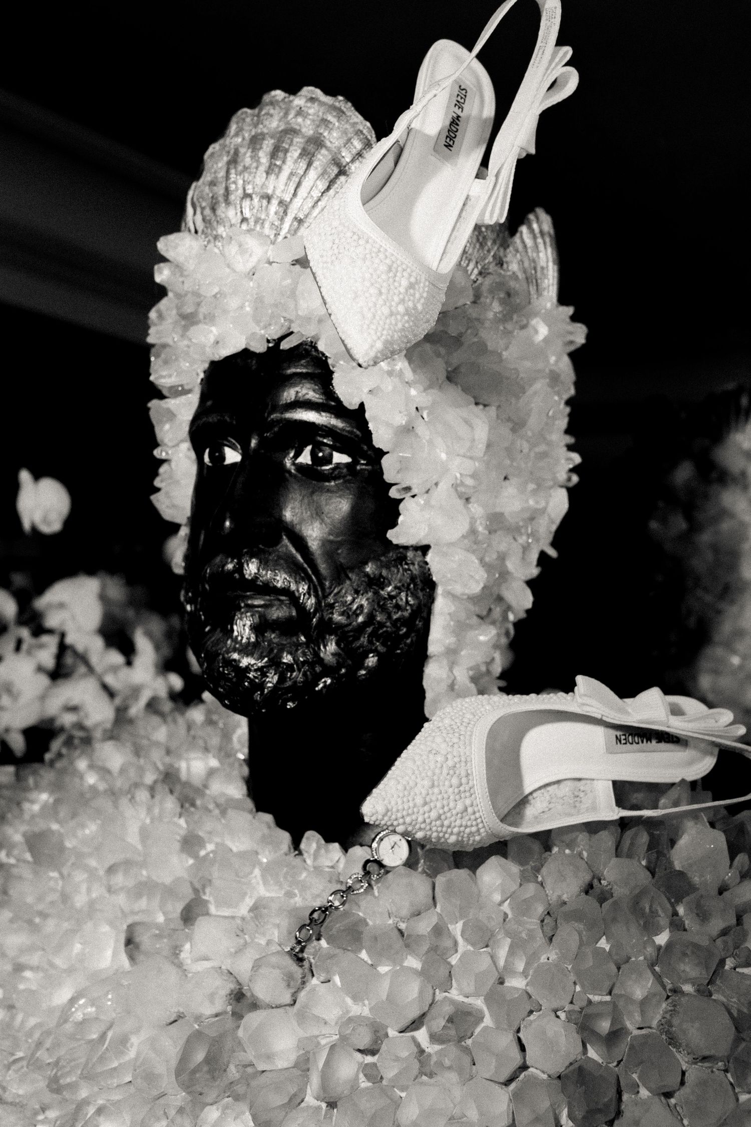 Artistic black and white close-up of a mask surrounded by crystalline ice formations.