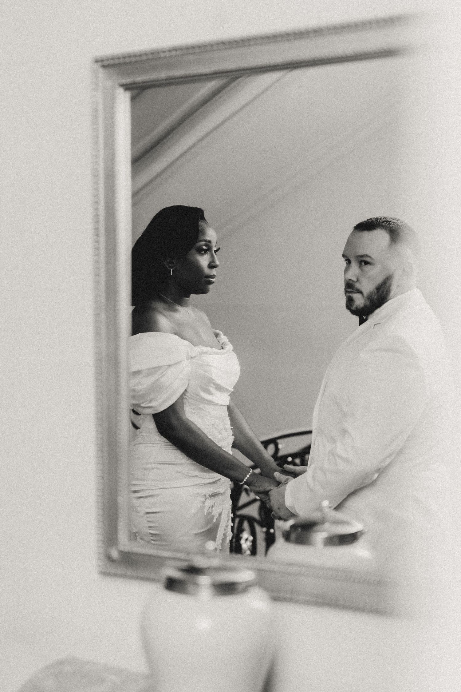 A series of black and white photographs showing two people in white clothing engaged in conversation at a table.