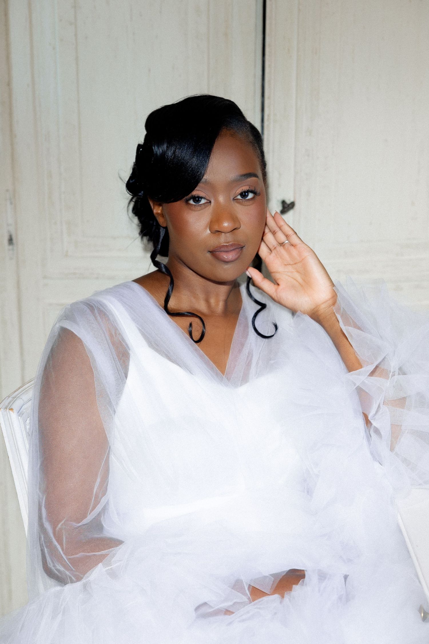 A series of four photos showing someone in a white sheer dress posing playfully against a light background.