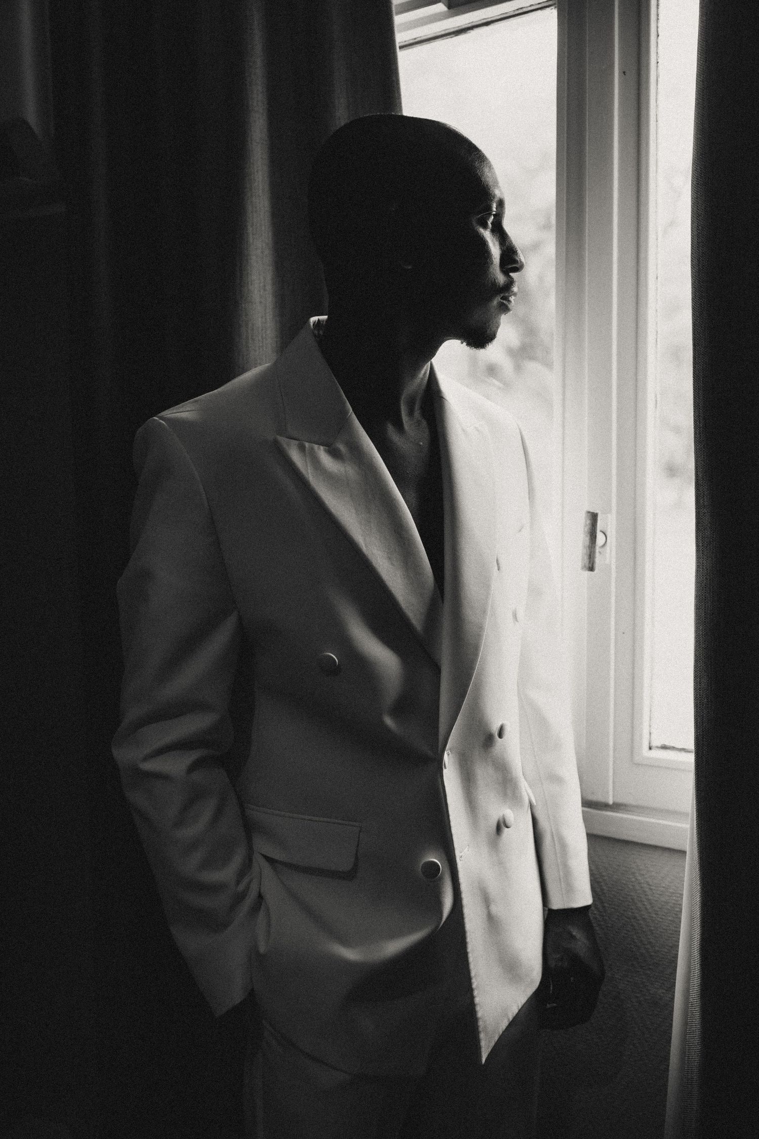 Dramatic black and white photo sequence showing silhouette of person in suit standing by window.