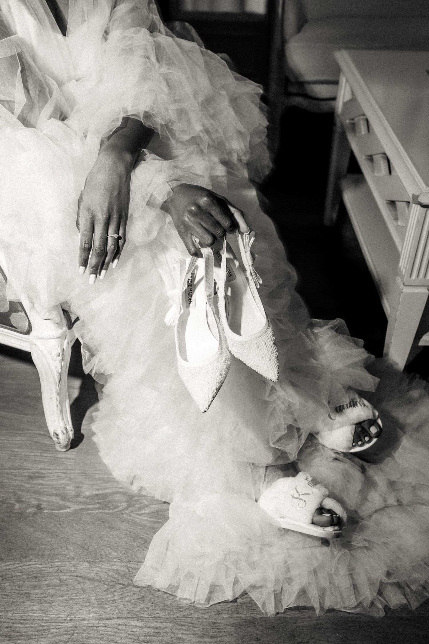 A series of black and white photos showing the bottom of a flowing tulle wedding dress and white shoes on hardwood floor.