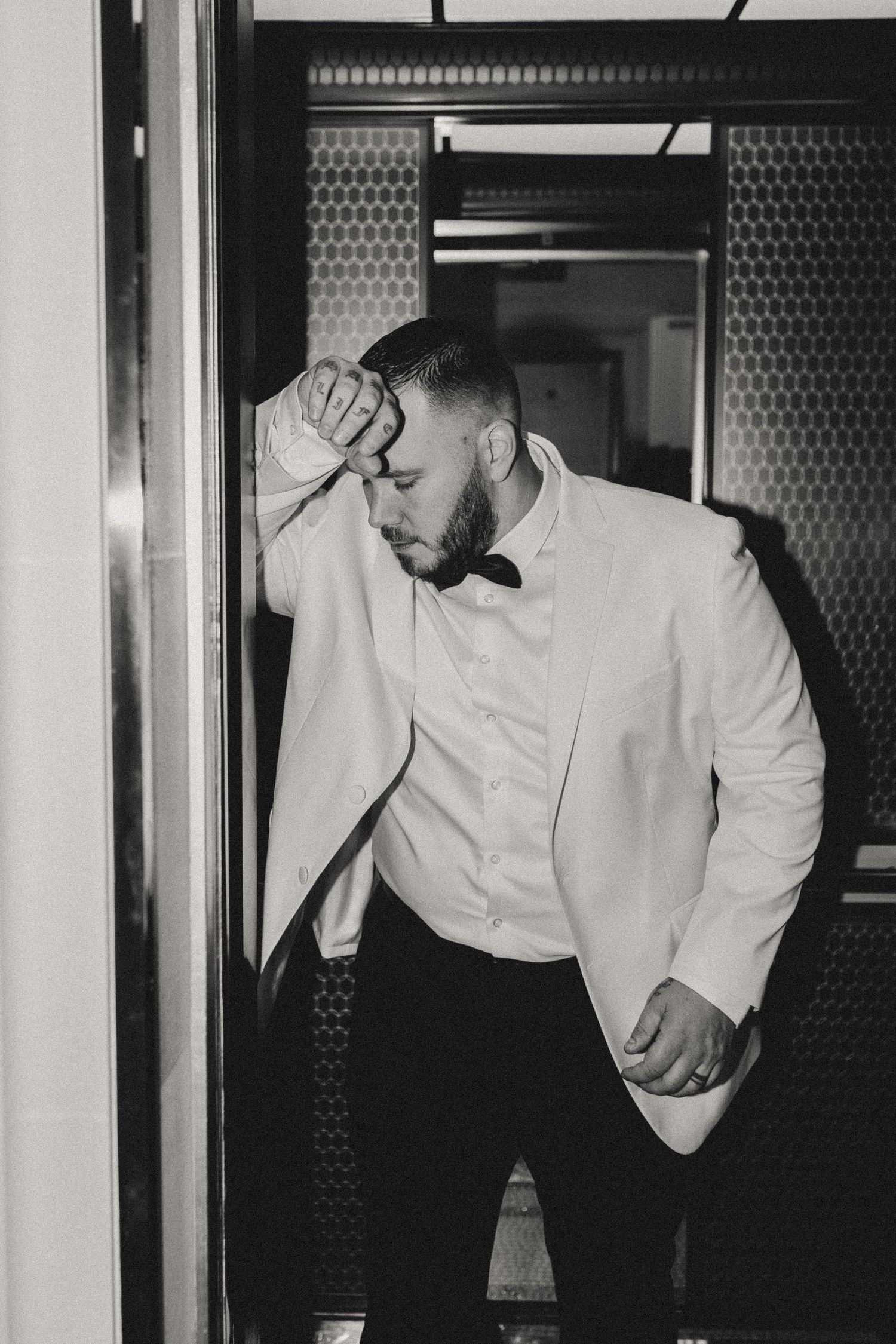 Black and white photo sequence showing a person in a white shirt leaning and moving against a textured wall.