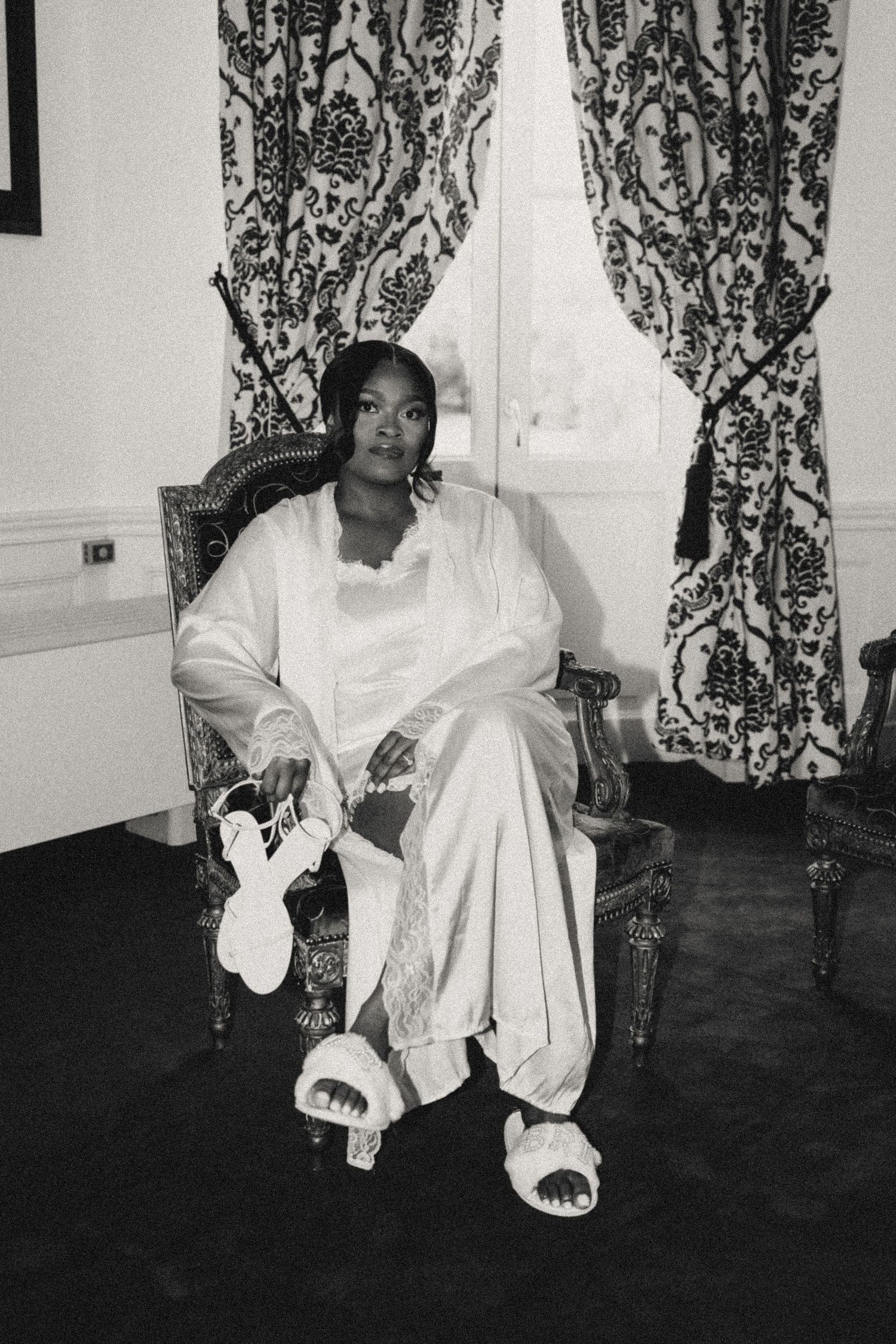 A series of black and white photos showing someone dancing in a white dress against a patterned curtain background.