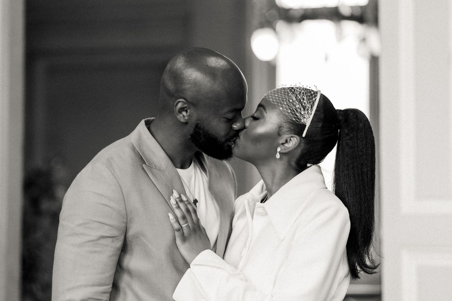 Sweet interaction between two people dressed in white against a bright interior backdrop.
