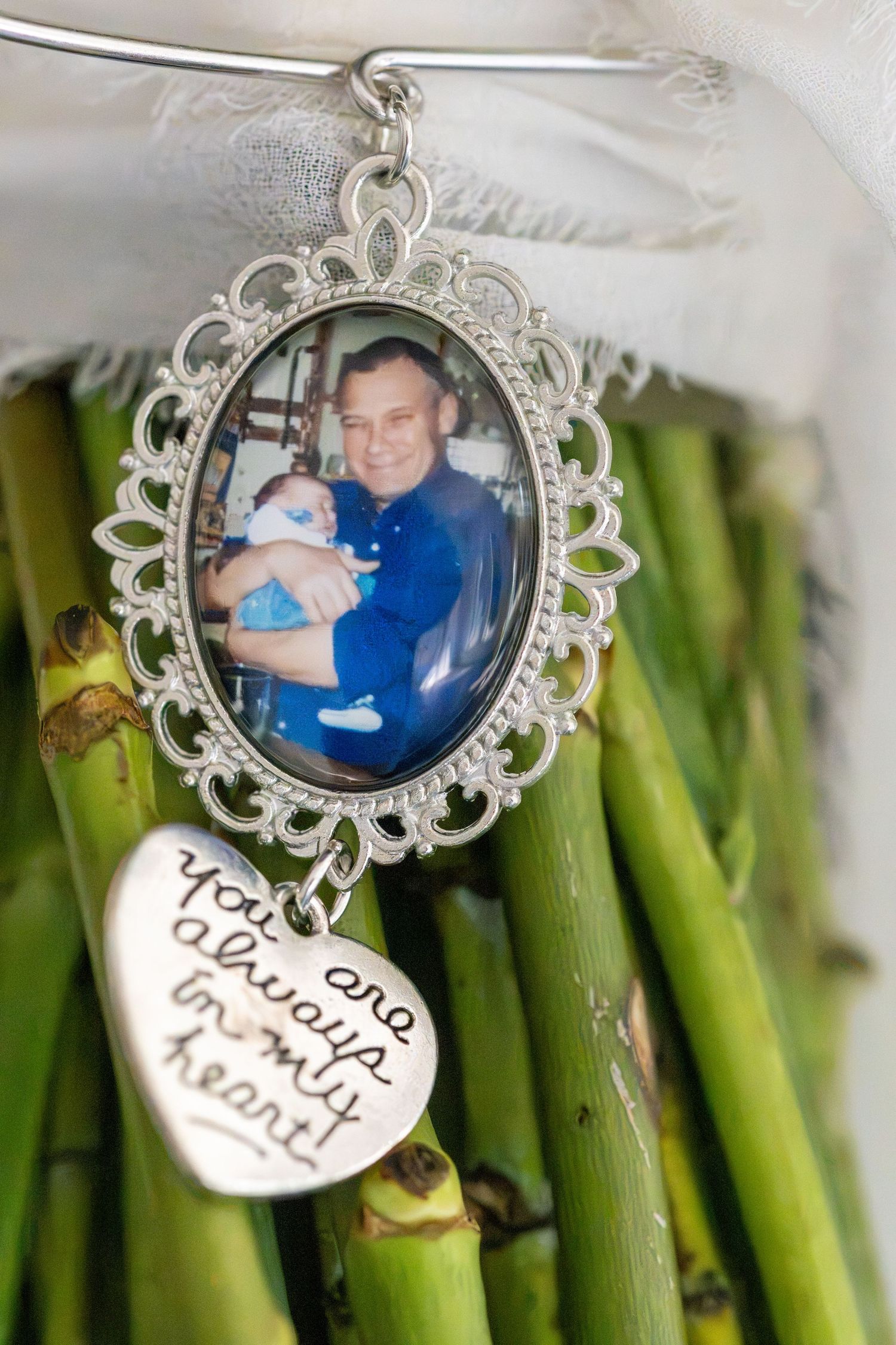 Wedding bouquet charm with oval photo frame and heart pendant reading you are always in my heart.