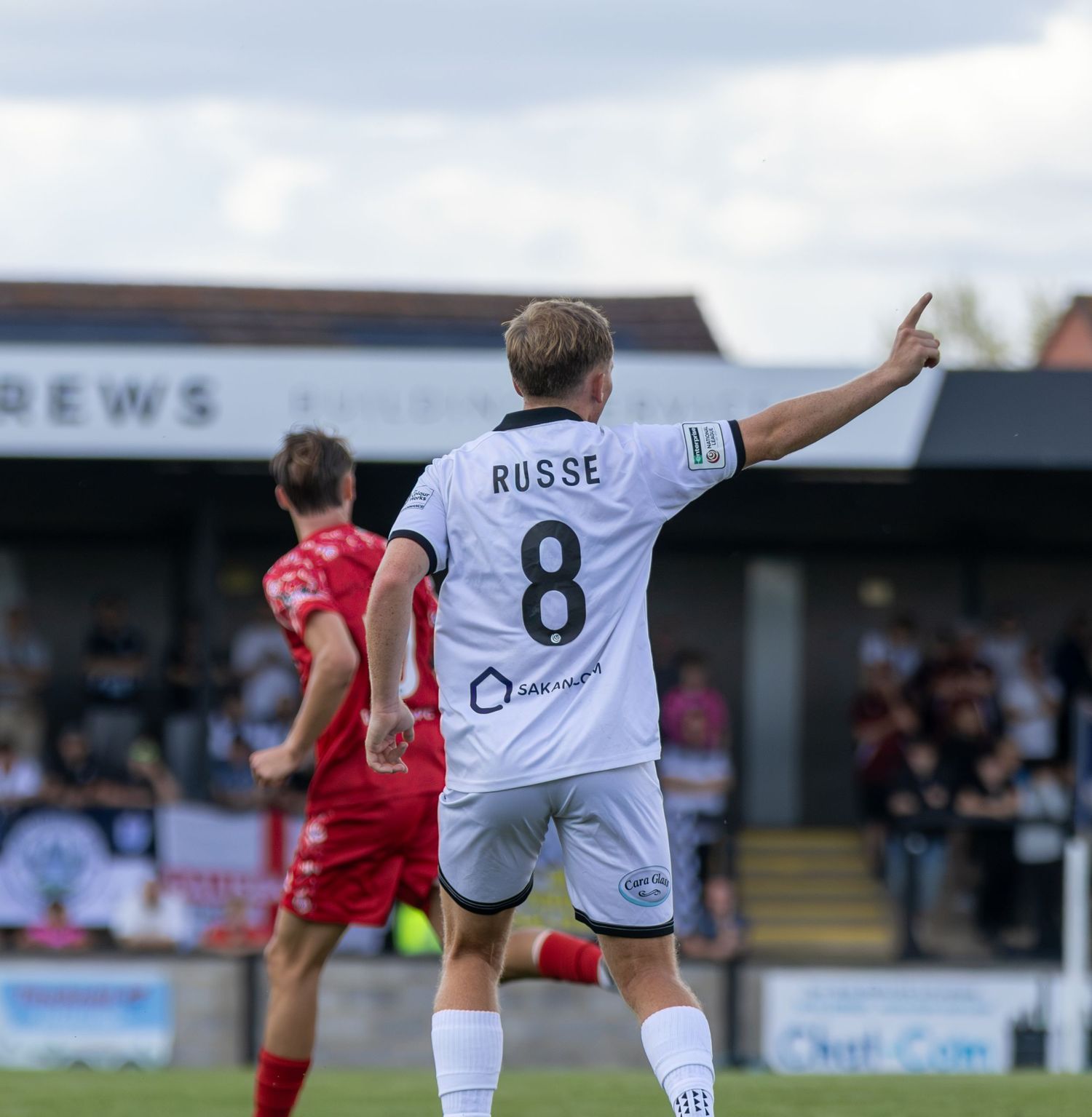Footballer Russe number 8 in white kit celebrates with finger pointing up after scoring a goal.