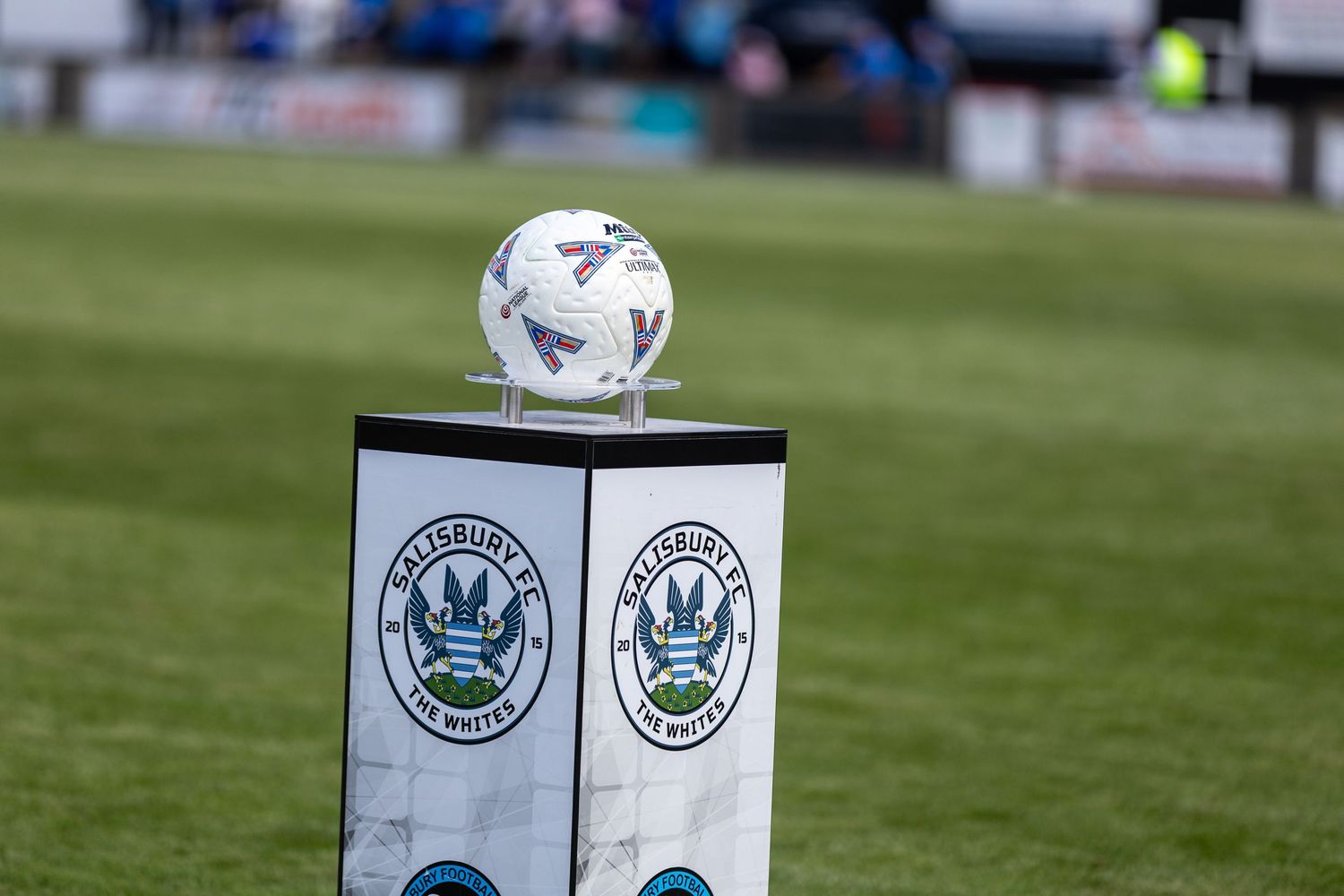 A soccer ball rests on a Waterford FC branded pedestal on the pitch before a match.
