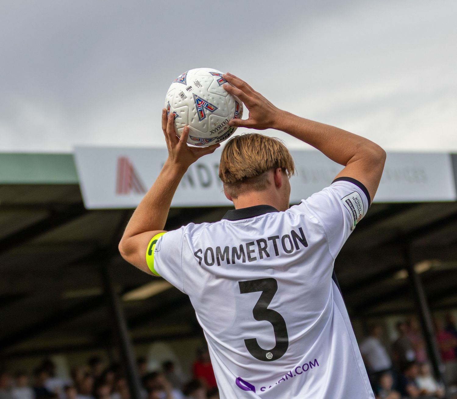 Salisbury FC player Sommerton number 3 takes a throw-in during a competitive football match.