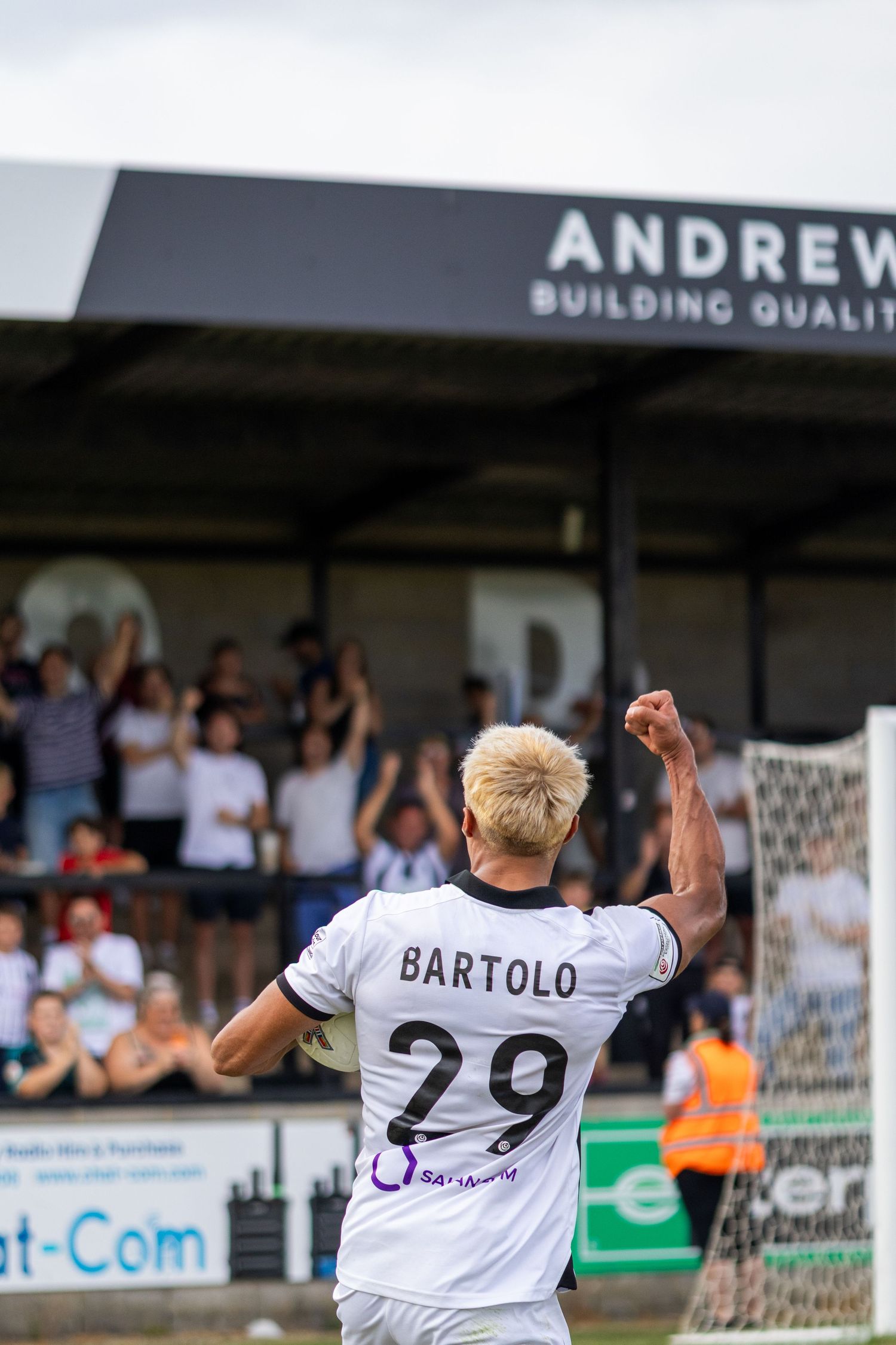 Bartolo number 29 raises fist celebrating goal with cheering crowd at Andrews Quality stadium.