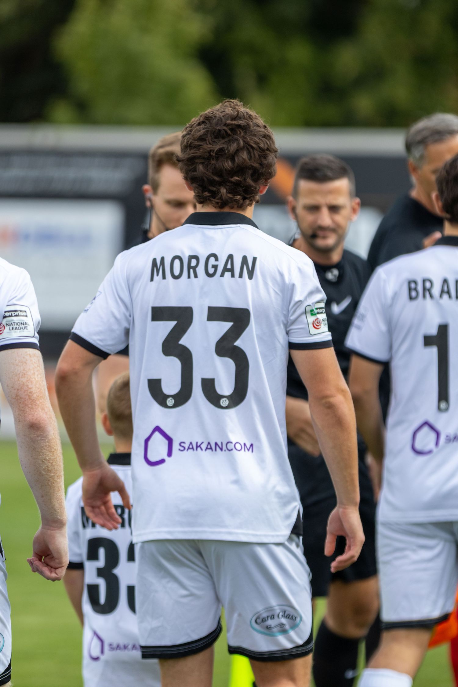 Player Morgan in number 33 white Sakan.com sponsored football kit during a pre-match walkout.