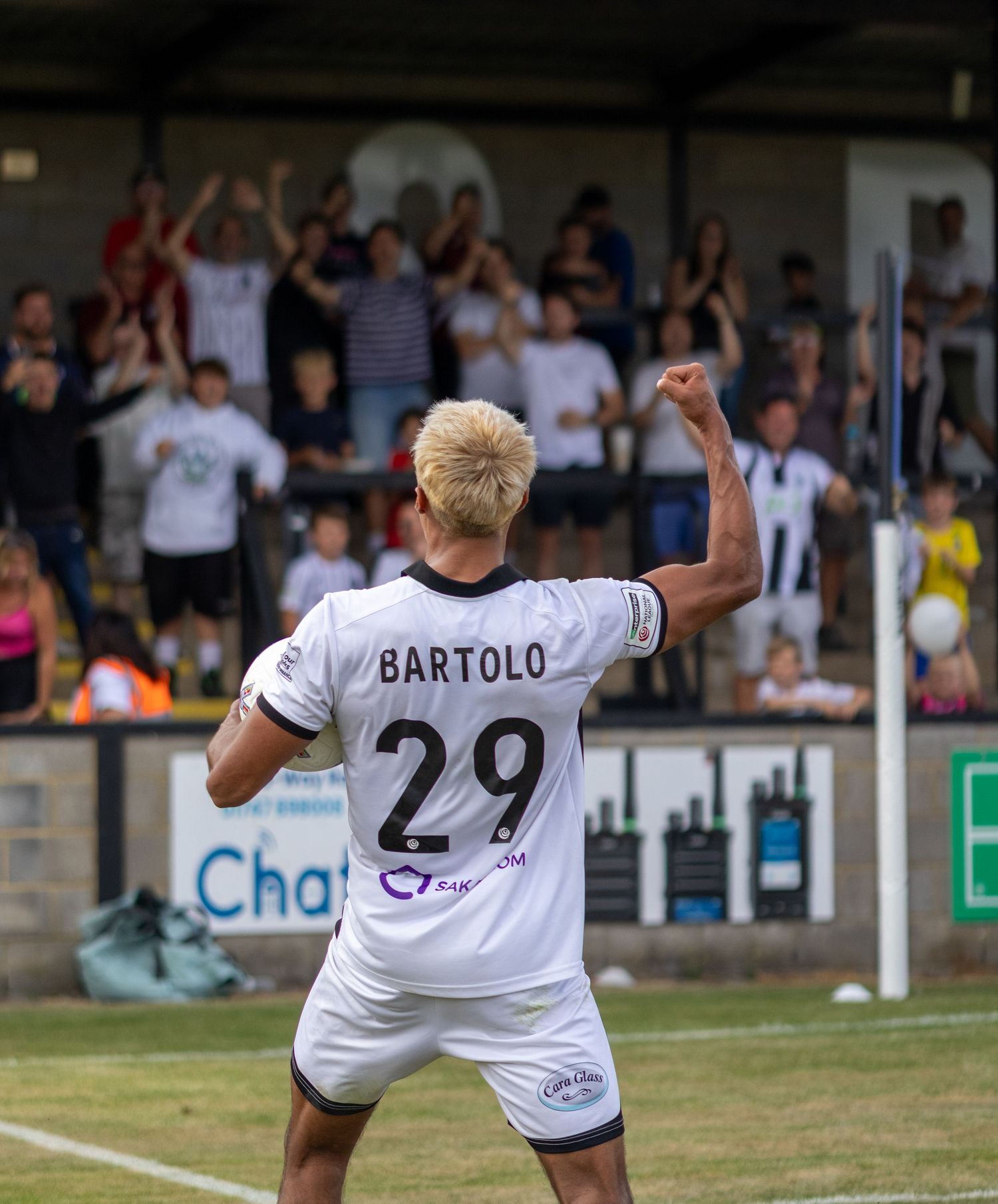 Soccer player Bartolo number 29 celebrates goal with raised fist in front of cheering crowd.