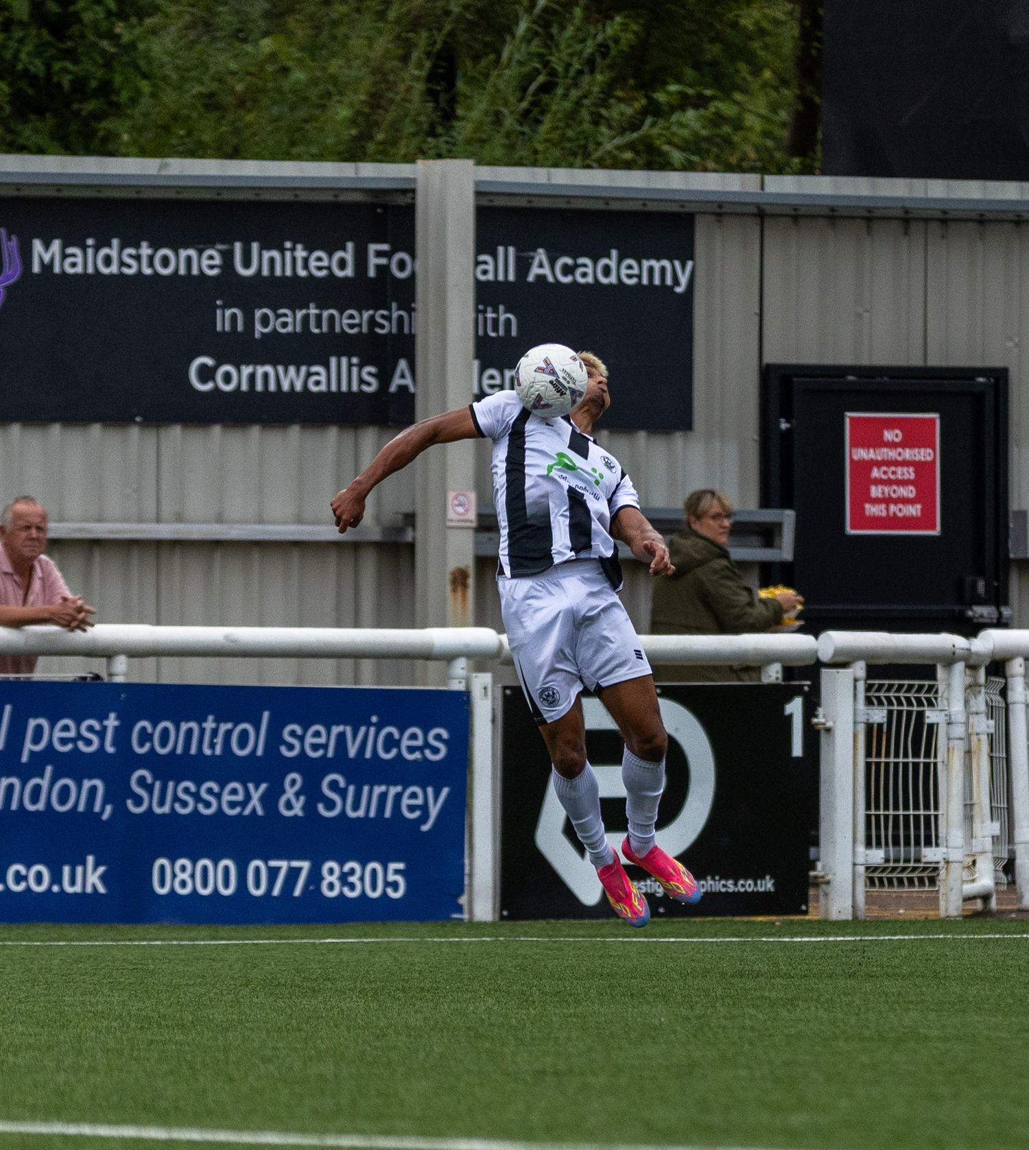 A Maidstone United footballer heads the ball during a match at the academy ground in Kent, England.