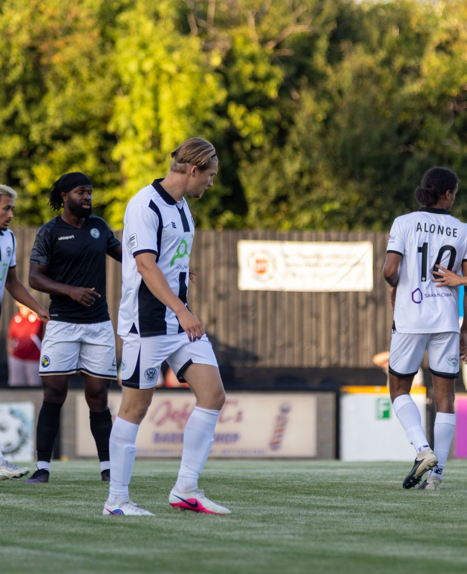 Football players in black and white kits on the pitch, with player Alonse wearing number 10 visible.