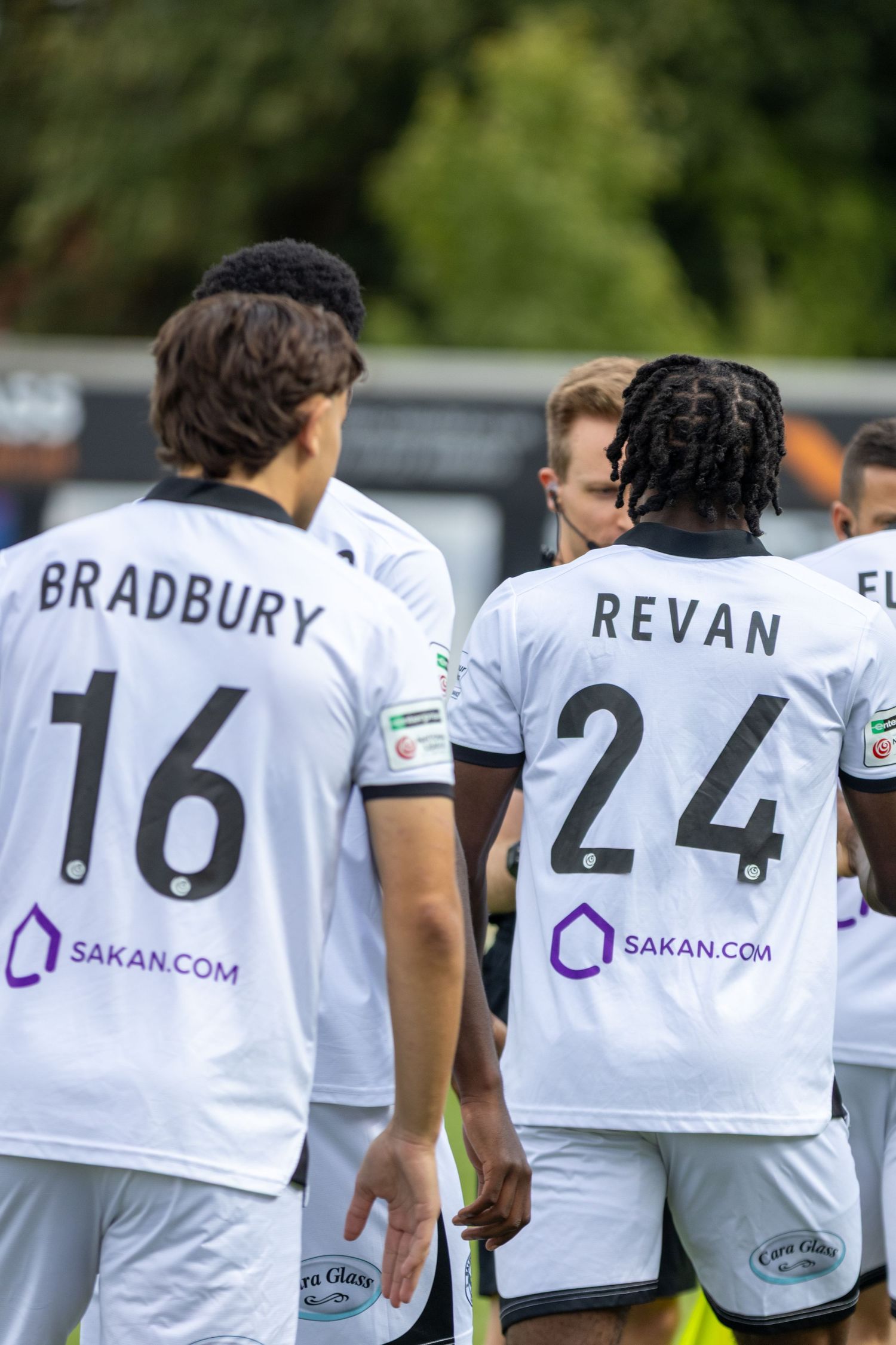 Footballers Bradbury number 16 and Revan number 24 in white Sakan.com sponsored kits.