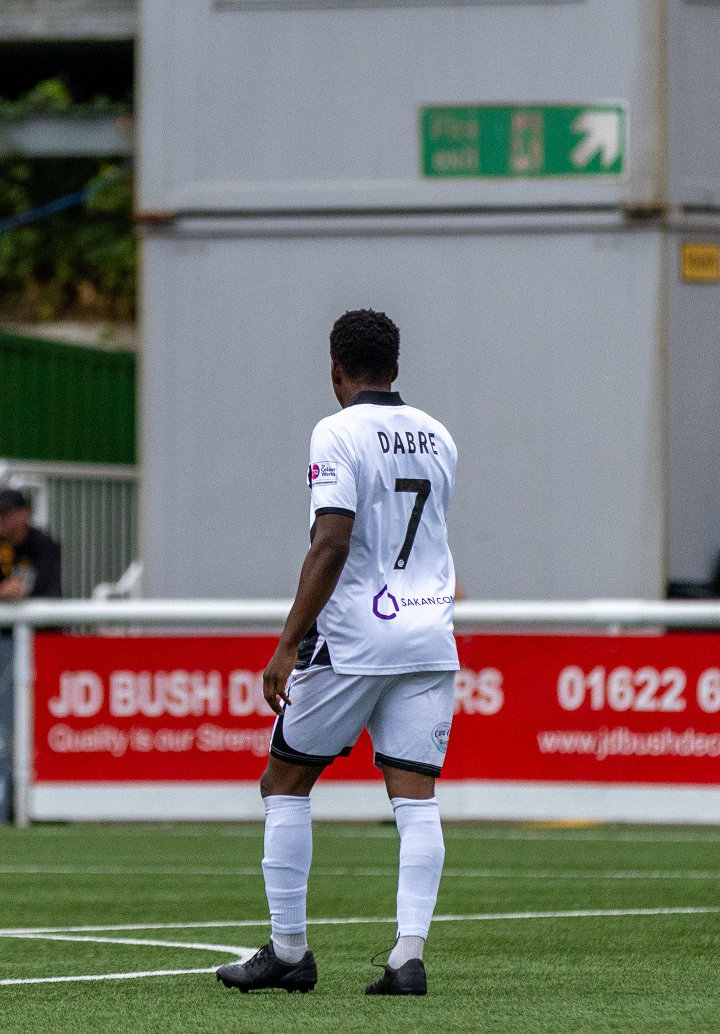 Soccer player Dabre wearing number 7 white jersey stands on green pitch during a match at JD Bush ground.