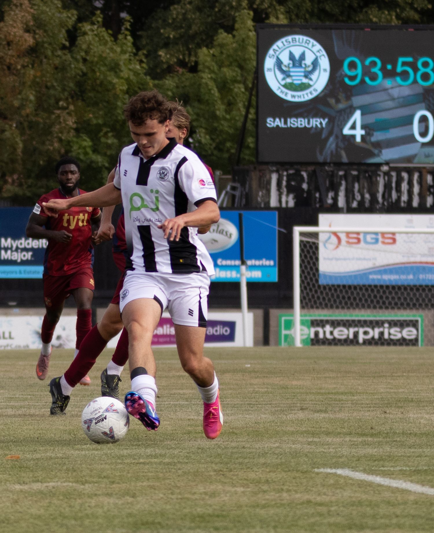 Salisbury FC lead 4-0 at 93:58 as player controls ball in black and white kit near touchline.