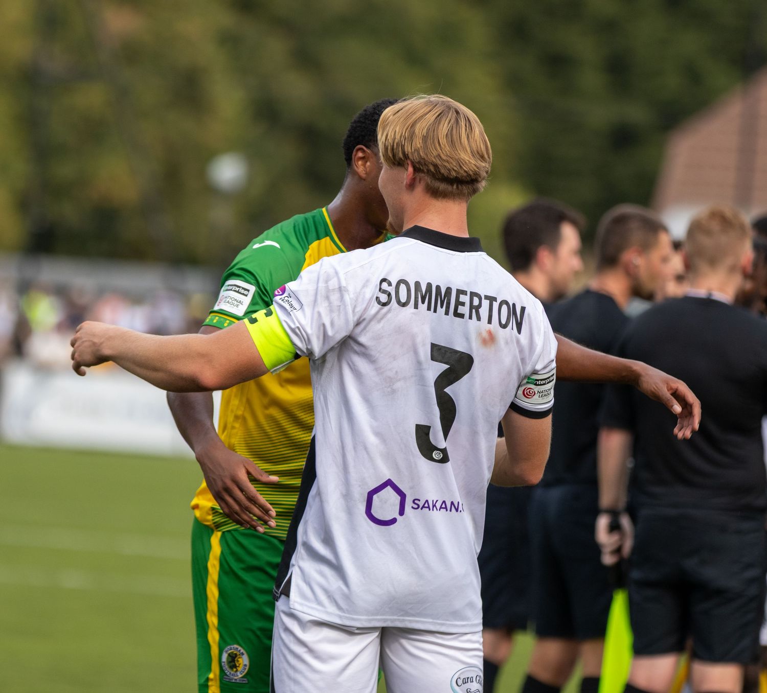 Player Sommerton in white number 3 jersey exchanges a friendly gesture with an opponent after a match.