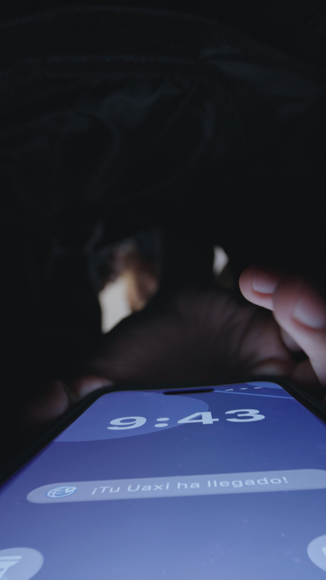 A smartphone screen displays 9:43 with a Uaxi delivery notification in a dark setting.