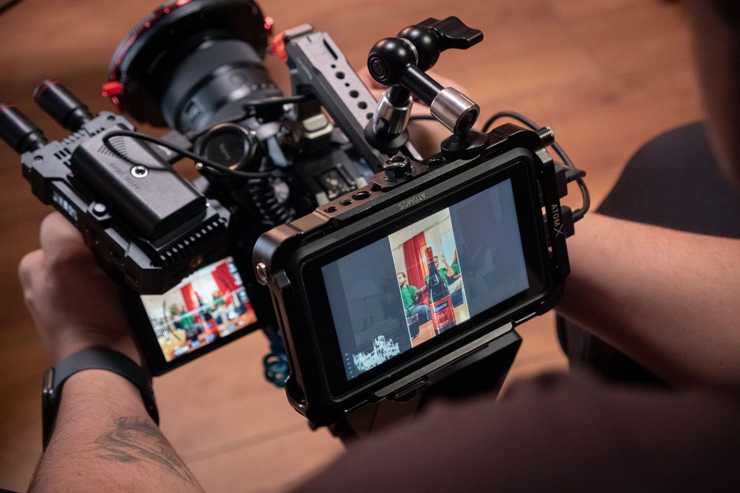 Filmmaker reviewing footage on a monitor attached to a professional cinema camera rig on set.