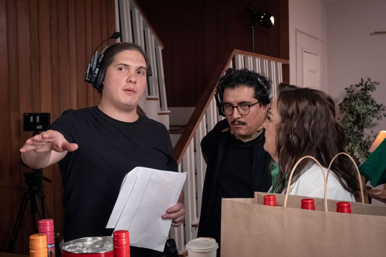 Film crew members reviewing script and discussing scene details on an indoor production set.