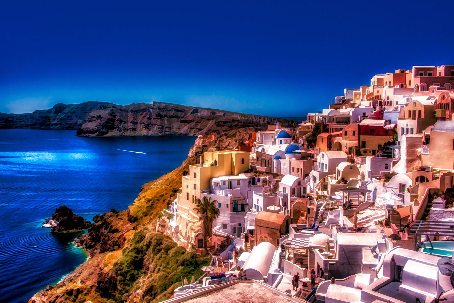 HDR sunset view of white-washed Santorini buildings cascading down cliffs above the Aegean Sea, Greece.