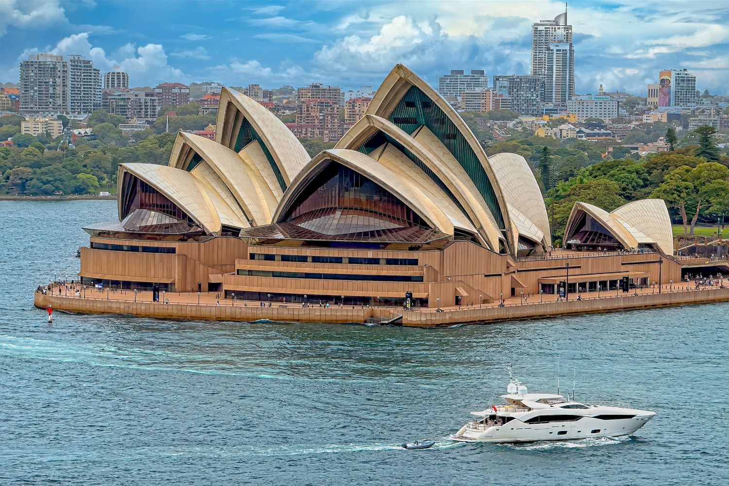 Aerial view of the iconic Sydney Opera House with its distinctive white shell-shaped roof beside Sydney Harbour.