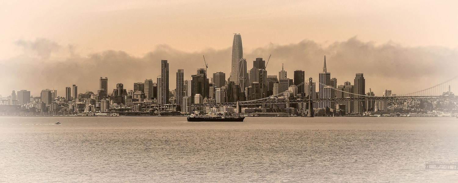 Sepia-toned panoramic view of San Francisco skyline with a sailboat on the bay, California, USA