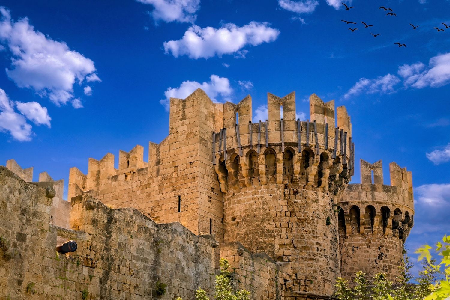 Medieval stone castle with battlements and round tower under a vivid blue sky with white clouds, Athlens, Greece.