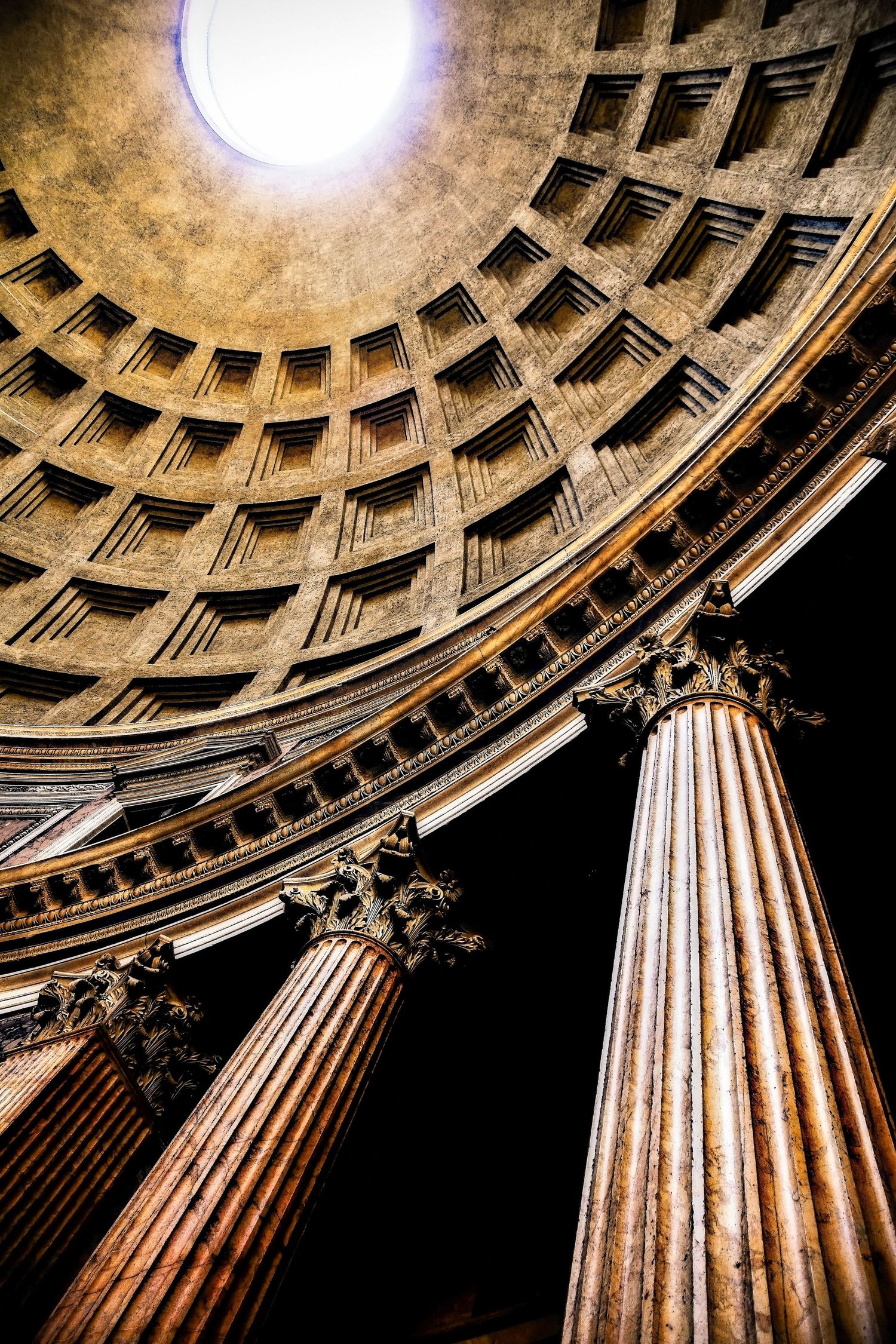 Dramatic low-angle view of the Pantheon interior in Rome, Italy, showcasing massive Corinthian columns and the famous oculus dome.