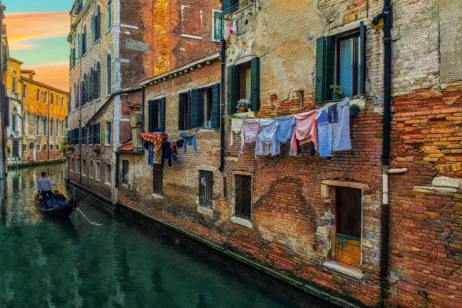 Colorful laundry hanging over a narrow Venice canal with gondola and aged brick buildings, Italy.