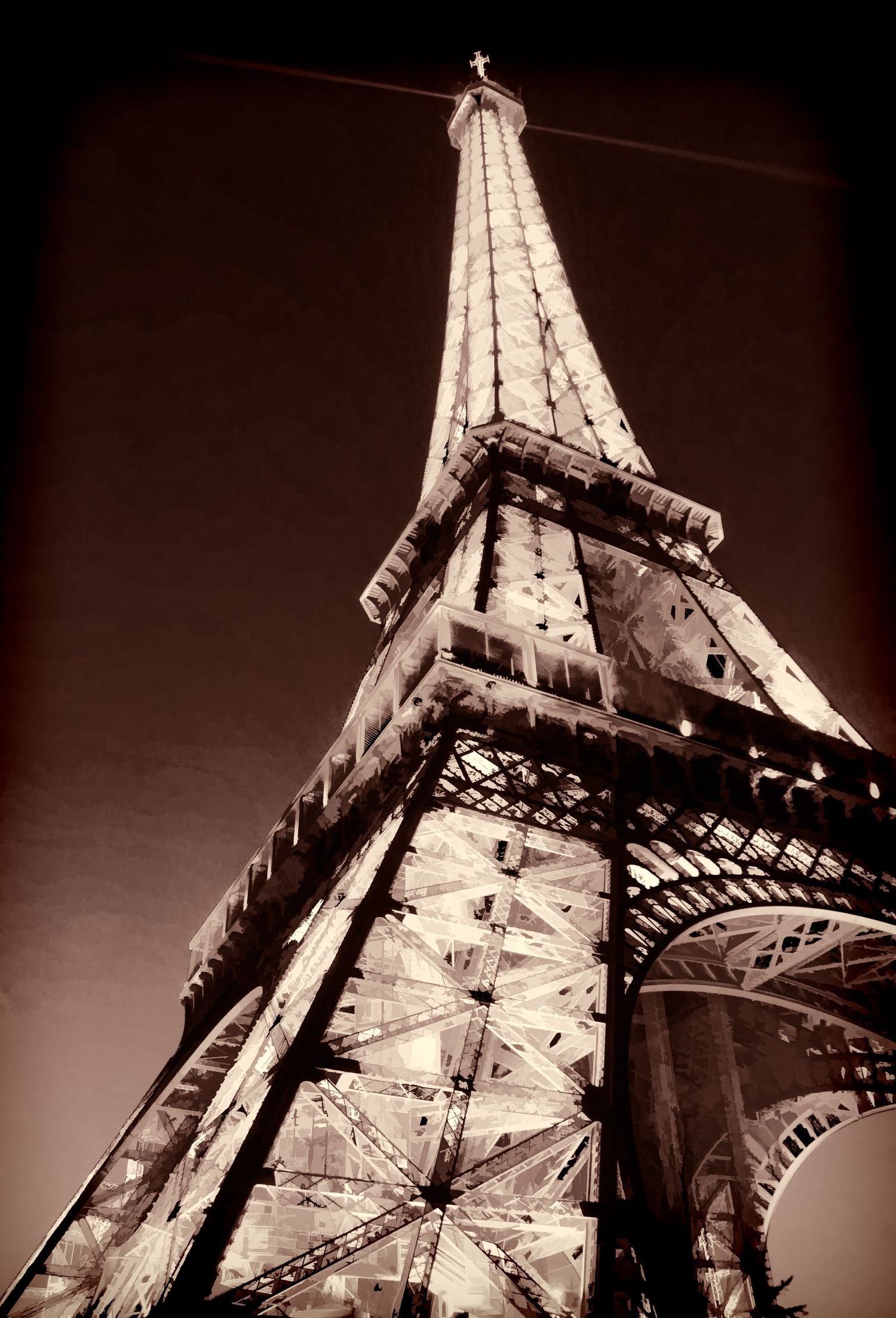 Dramatic sepia-toned low-angle view looking up at the iconic Eiffel Tower structure against a dark sky in Paris, France.