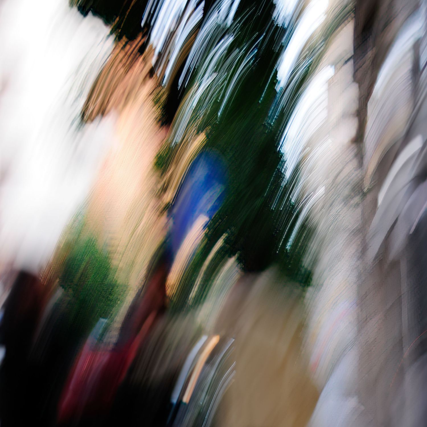 Abstract motion blur photography with streaks of green, blue, and white creating a dynamic, artistic urban scene.