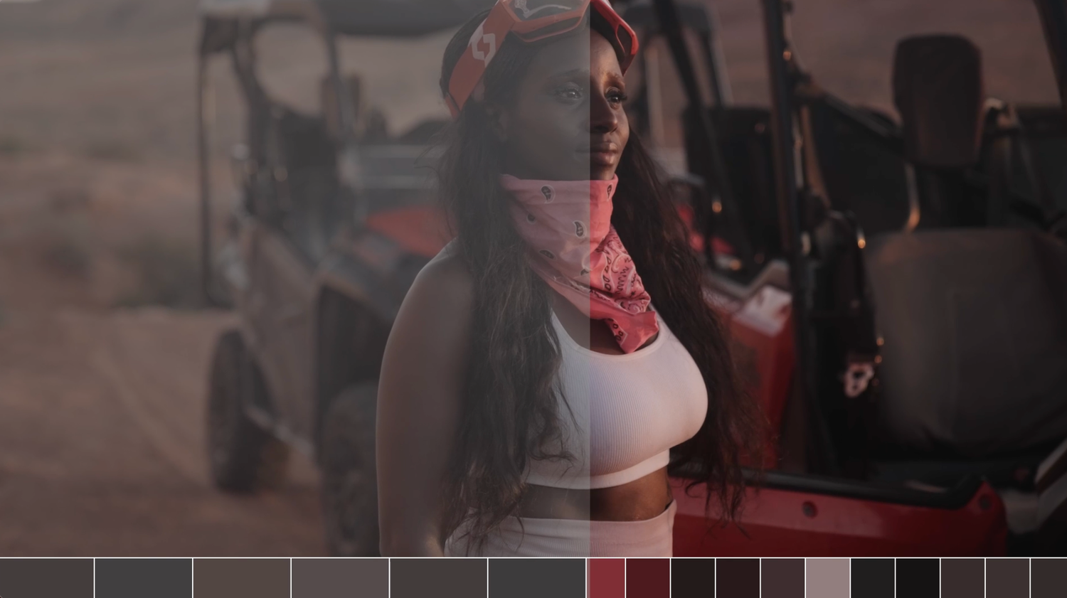 Woman in white crop top and pink face covering poses near a red off-road vehicle in a desert setting.